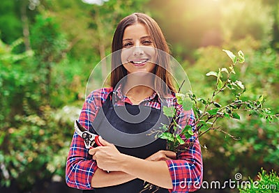 Smiling young female gardener pruning the plants Stock Photo