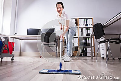 Female Janitor Cleaning Floor In Office Stock Photo