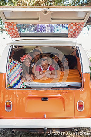 Smiling young friends lying in camper van Stock Photo