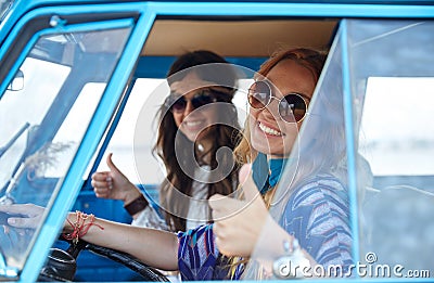 Smiling young hippie women driving minivan car Stock Photo