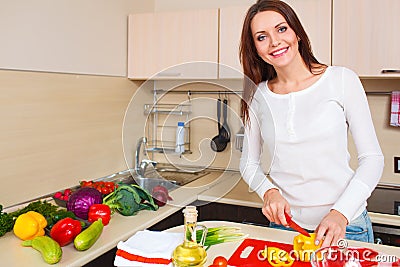 Smiling young housewife mixing fresh salad Stock Photo