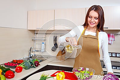 Smiling young housewife mixing fresh salad Stock Photo