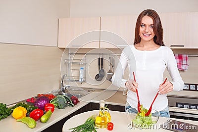 Smiling young housewife mixing fresh salad Stock Photo