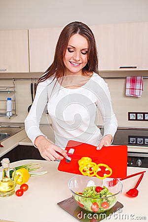 Smiling young housewife mixing fresh salad Stock Photo