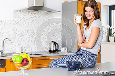 Smiling young lady with glass of milk Stock Photo