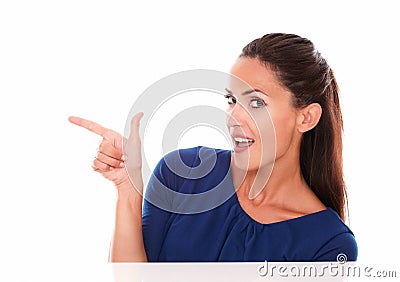 Smiling young lady pointing to her right Stock Photo