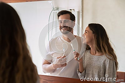 Happy young couple brush teeth in bathroom together Stock Photo