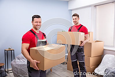 Smiling Young Male Relocation Worker Carrying Cardboard Boxes Stock Photo