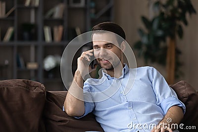 Smiling young man enjoy phone talk holding gadget at ear Stock Photo