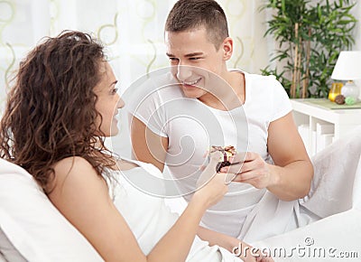 A smiling young man gives a girl a gift Stock Photo