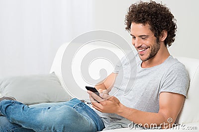 Smiling Young Man Holding Cellphone Stock Photo