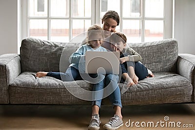 Happy kids siblings enjoying using computer apps with mommy. Stock Photo