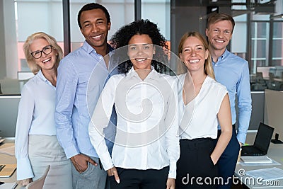 Smiling young african leader looking at camera with diverse team Stock Photo