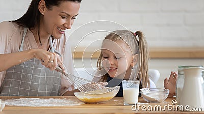 Happy mom and daughter cooking pancakes together Stock Photo