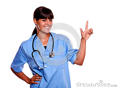 Smiling young nurse looking at you pointing up Stock Photo