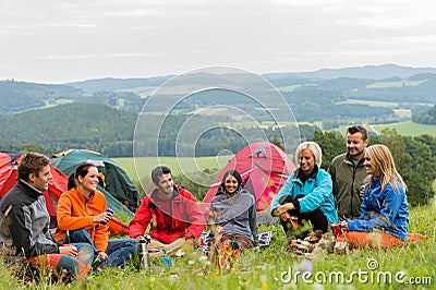 Sitting camping friends with tents and landscape Stock Photo