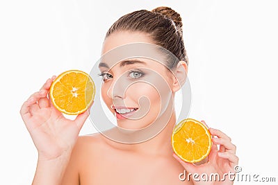 Smiling young pretty woman holding two halves of orange Stock Photo