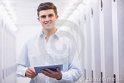 Smiling young technician working with his tablet Stock Photo