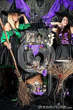 Smiling young witches with broomsticks and potions Stock Photo