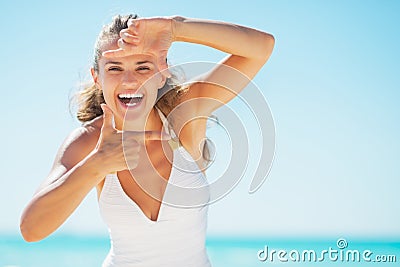 Smiling young woman on beach framing with hands Stock Photo