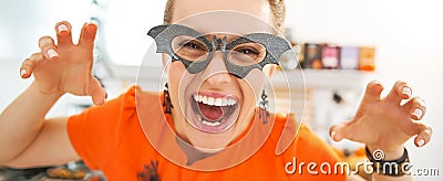 Smiling young woman in Halloween decorated kitchen frightening Stock Photo