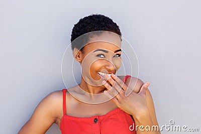 Smiling young woman with hand covering mouth Stock Photo