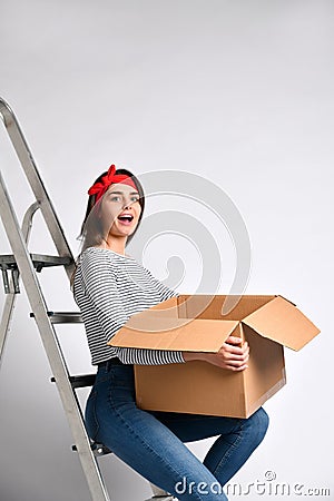 Pretty woman standing on light background with moving cardboard box Stock Photo