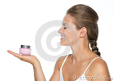 Smiling young woman holding cream bottle Stock Photo
