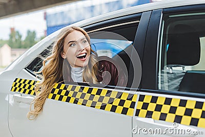 smiling young woman looking away through taxi window Stock Photo