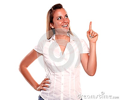 Smiling young woman looking and pointing up Stock Photo