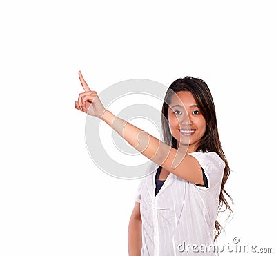 Smiling young woman looking at you and pointing up Stock Photo