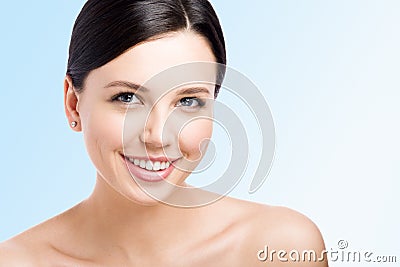 Smiling young woman. Perfect clean skin. Kind face. Closeup beauty on blue Stock Photo