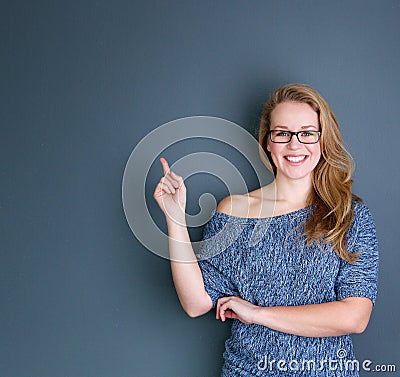 Smiling young woman pointing finger Stock Photo