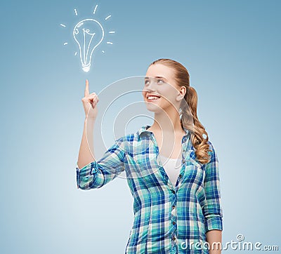 Smiling young woman pointing finger up Stock Photo