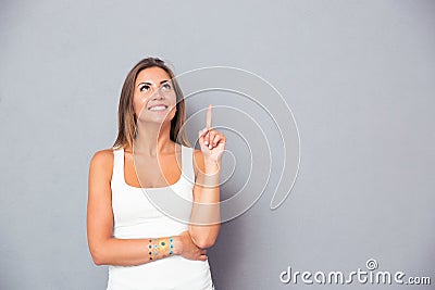 Smiling young woman pointing finger up Stock Photo