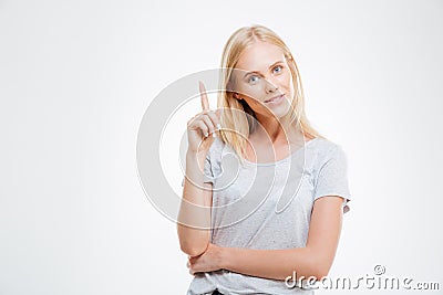 Smiling young woman pointing finger up Stock Photo