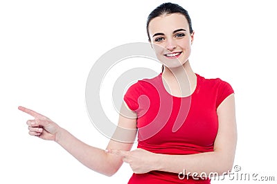 Smiling young woman pointing to her right Stock Photo