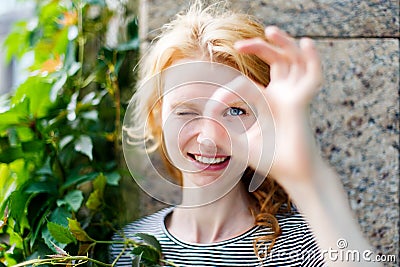 Smiling young woman showing OK sign and looking at camera Stock Photo