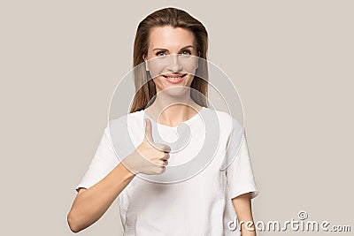 Smiling young woman showing thumbs up gesture, satisfied client Stock Photo