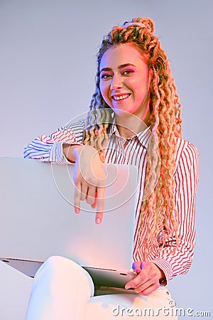 Smiling woman shows the comfortability of using wireless technology Stock Photo