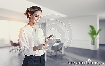 Smiling young woman using tablet in office Stock Photo