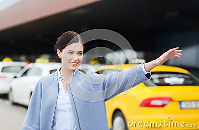 Smiling young woman waving hand and catching taxi Stock Photo