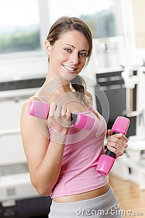 Smiling young woman weightlifting at the gym Stock Photo