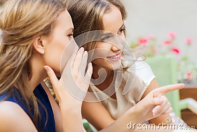 Smiling young women gossiping at outdoor cafe Stock Photo
