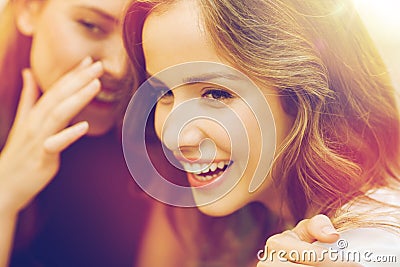 Smiling young women gossiping and whispering Stock Photo