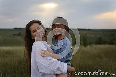 Photo of a woman with a six year old daughter in her arms Stock Photo