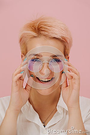 Smilng young woman with short blond hair, round glasses and stars eye makeup Stock Photo