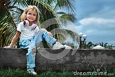Smily caucasian kid girl with headphones looking in camera. Stock Photo