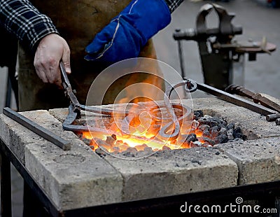 The smith heats until red a metal detail in a forge brazier Stock Photo