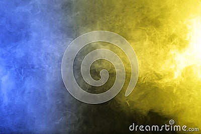 Smoke in blue yellow light on black background Stock Photo